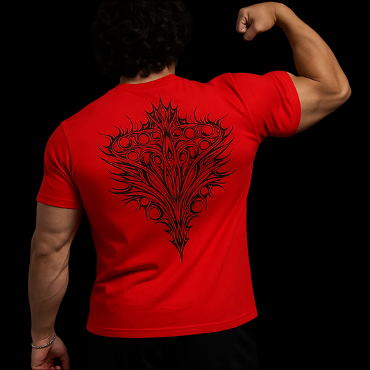 Person wearing a red t-shirt with a black tribal design on the back against a black background